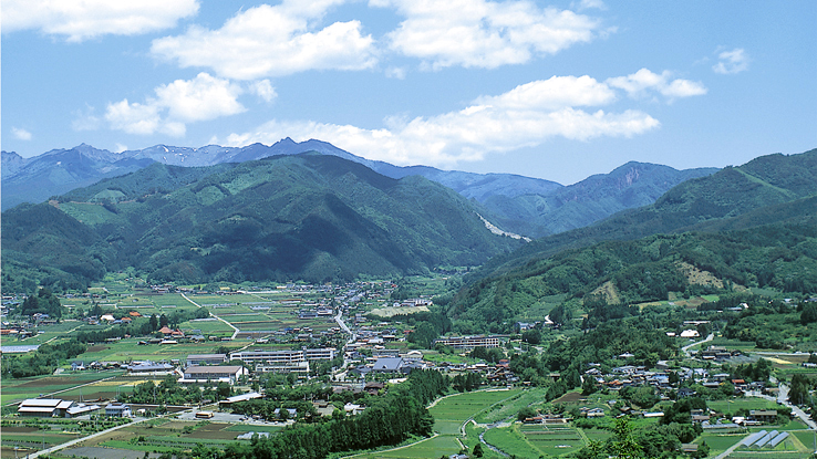 Scenic valley town amidst lush green mountains.