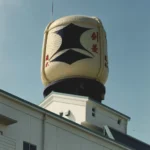 Giant logo for Kenbishi Brewery on building rooftop.