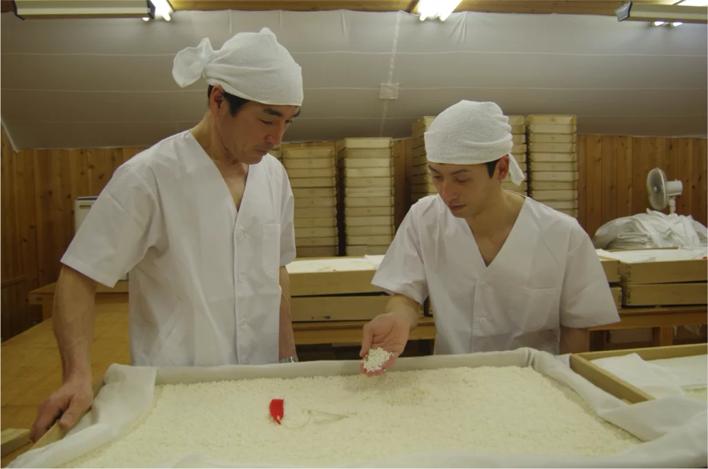 Chefs making traditional Japanese rice in the kitchen.