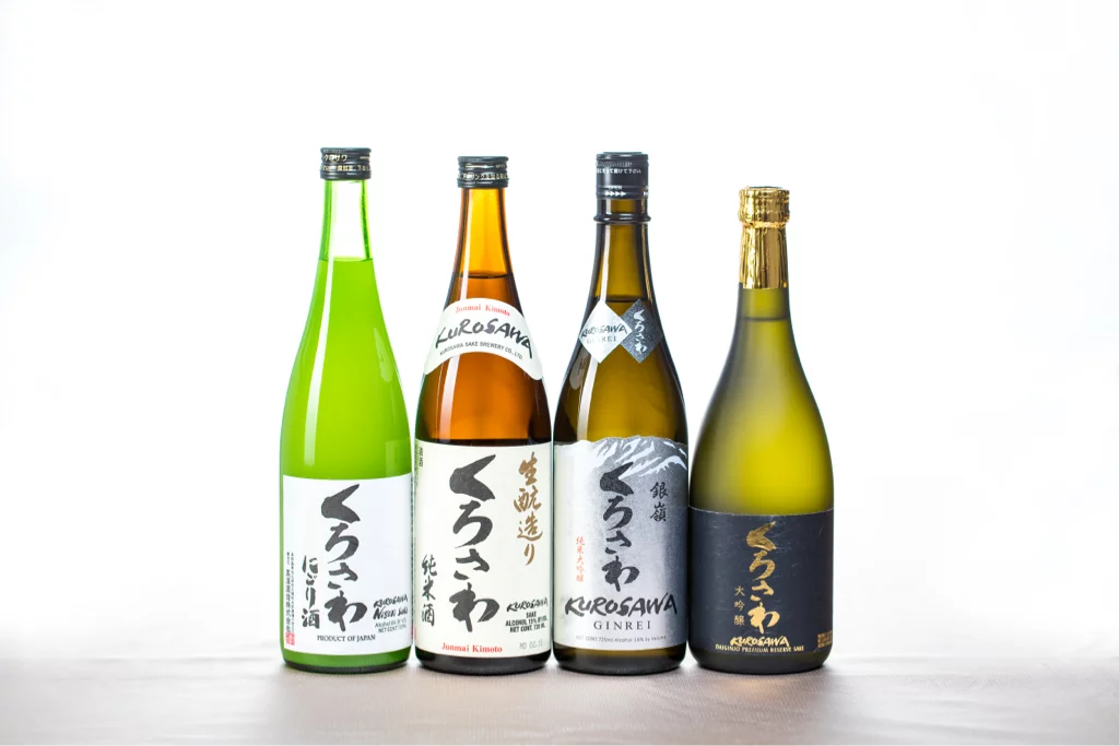 Assorted Japanese sake bottles on white background.